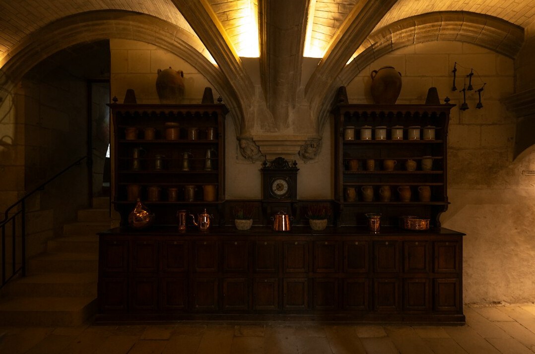 Old library with tall wooden shelves full of vintage books in warm light
