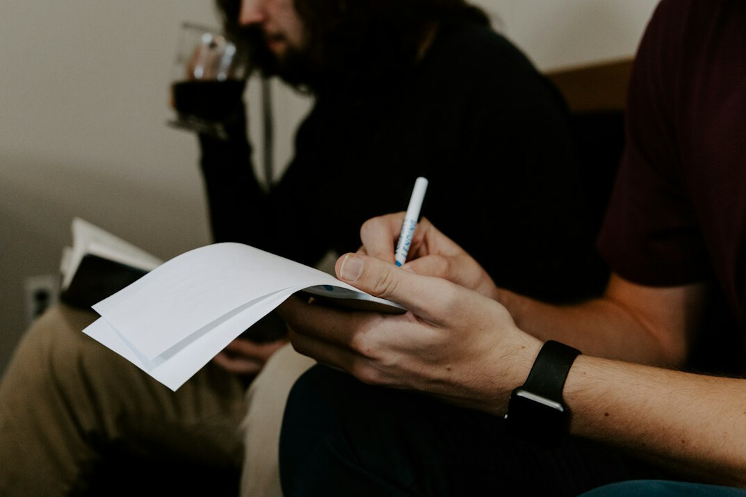 person writing notes in notebook