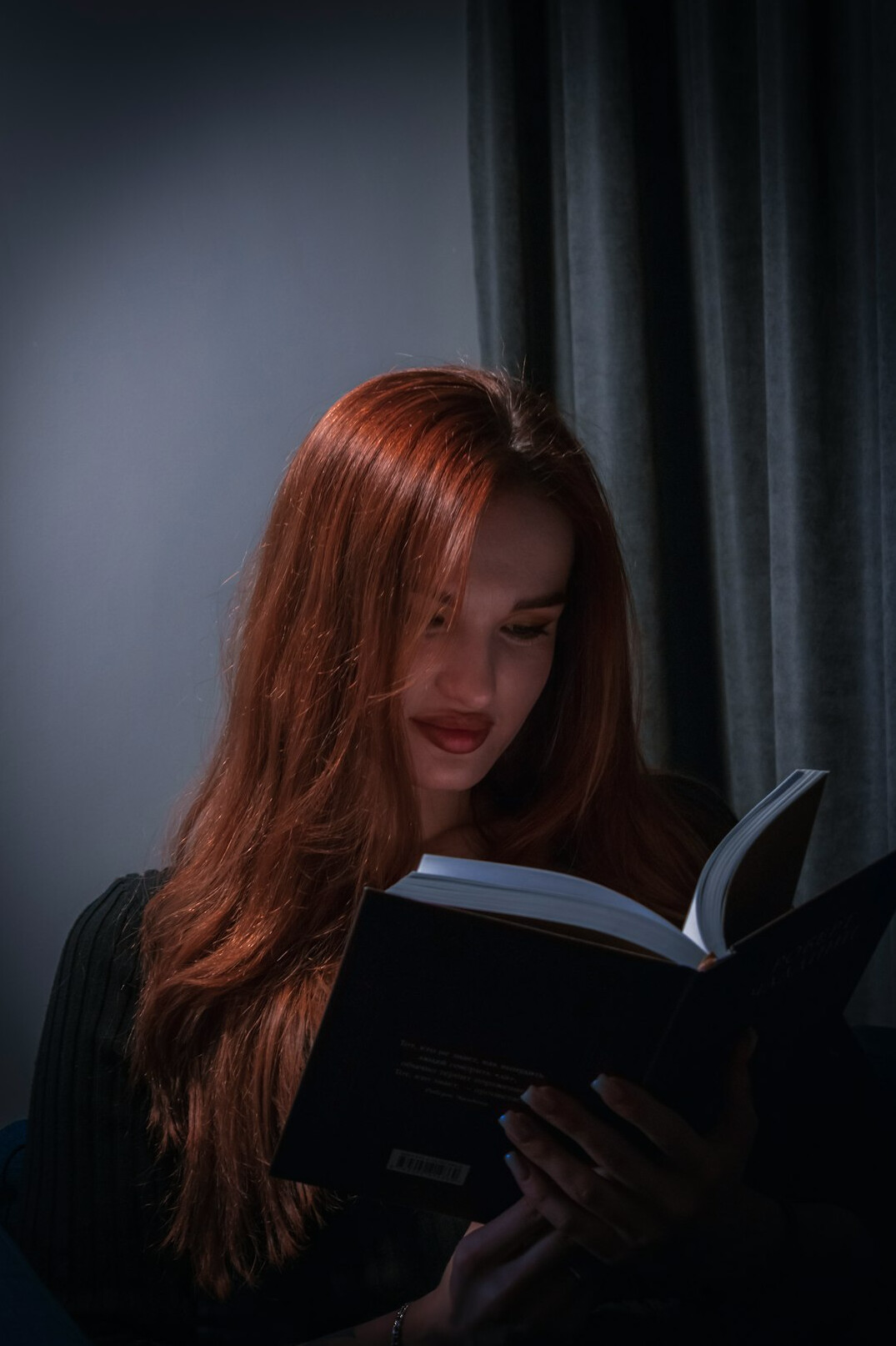 woman reading book at night